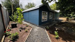 a blue house with some plants in a yard at Green House, by Pewma Apart Hotel in Diguillín