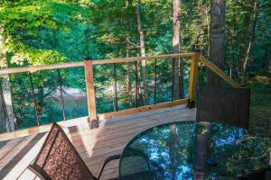 a balcony with a glass table and chairs on a deck at Salt Creek Cabin in Chillicothe