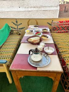 a table with plates of food and a tea pot on it at NUB Guest House in Aswan