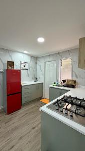 a kitchen with a red refrigerator and a counter top at Green House, by Pewma Apart Hotel in Diguillín