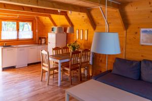 a living room with a table and chairs and a kitchen at Słoneczna Przystań in Sasino