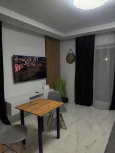 a dining room with a wooden table and chairs at Aura Apartamenty 3 in Brzeg