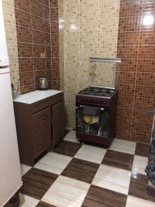 a kitchen with a stove and a tiled floor at NUB Guest House in Aswan