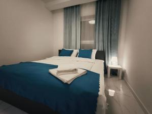 a bedroom with a large bed with a blue blanket at Aura Apartamenty 3 in Brzeg