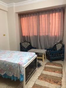 a bedroom with a bed and two chairs and a window at NUB Guest House in Aswan