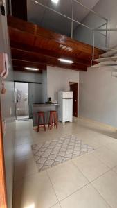 a large kitchen with a counter and a refrigerator at loft - studio excelente localização! in São Félix do Xingu