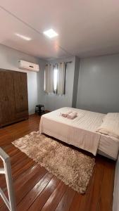 a bedroom with a large bed and a rug at loft - studio excelente localização! in São Félix do Xingu