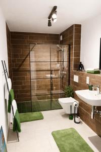 a bathroom with a shower and a toilet and a sink at Nivas Collection - Neubau Luxus Apartment in Montabaur +35 photos