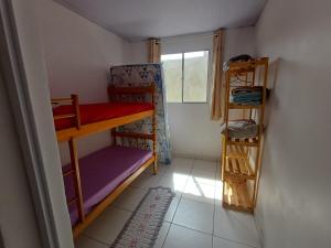 a small room with bunk beds and a window at Casa simples a 375 mts da praia in Matinhos