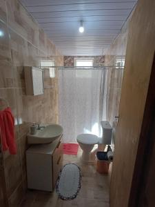 a bathroom with a sink and a toilet at Casa simples a 375 mts da praia in Matinhos