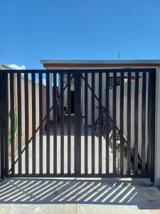 a gate on a house with a beach behind it at Casa simples a 375 mts da praia in Matinhos +5 photos