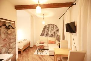 a living room with a white couch and a tv at Naschpark Dream Apartments! in Vienna