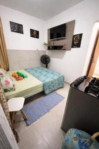 a small room with a bed and a table at Kitnet Dream House 2 in Bayeux