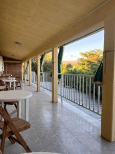 a porch with a table and chairs and a balcony at El Pino Departamentos in Villa Cura Brochero