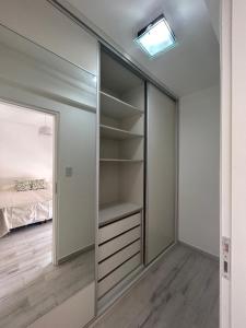 a walk in closet with a mirror and a bed at Moderno dpto céntrico 1 dormitorio , luminoso y cómodo , con cochera opcional in Santa Fe