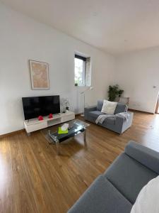 a living room with a couch and a tv at Modern refine home in Bellerive