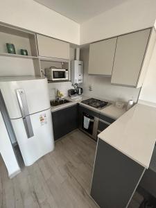 a kitchen with a white refrigerator and a stove at Moderno dpto céntrico 1 dormitorio , luminoso y cómodo , con cochera opcional in Santa Fe