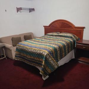 a bedroom with a bed with a blanket on it at Budget Inn in Somers Point