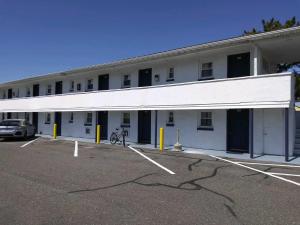 a large white building with a car parked in a parking lot at Budget Inn in Somers Point