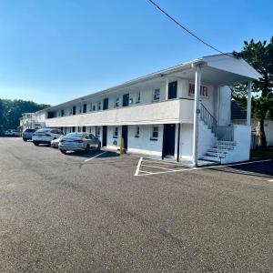 a large white building with cars parked in a parking lot at Budget Inn in Somers Point