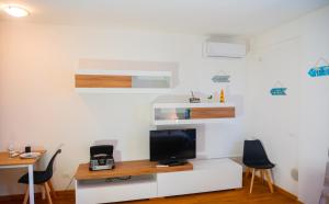 Ein Zimmer mit Schreibtisch, Fernseher und zwei Stühlen in der Unterkunft Paper House in Rom