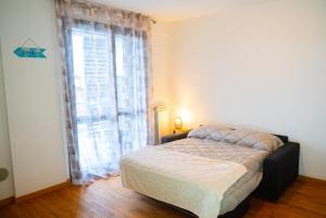 ein Schlafzimmer mit einem Bett und einem großen Fenster in der Unterkunft Paper House in Rom
