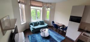 a living room with a blue couch and a table at Kęstučio 66 apartamentai in Kaunas