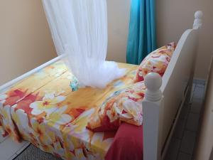 a bedroom with a bed with a flower patterned sheets at Les Tourterelles in Sainte-Luce