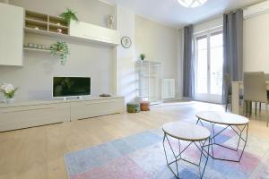 a living room with two tables and a tv at Ak Holidays Apartment 59 in Bologna