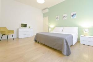 a white bedroom with a bed and a chair at Ak Holidays Apartment 59 in Bologna