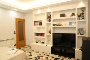 a living room with a flat screen tv and shelves at Paradiso dell'Etna in Zafferana Etnea