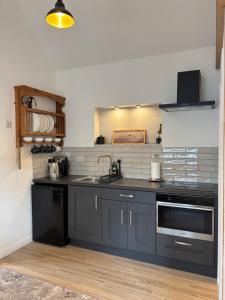 a kitchen with a sink and a stove top oven at Stable Lodge in Killarney