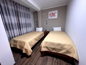 two beds sitting in a room with curtains at EL GRAN SEÑORIAL in Jauja +8 photos