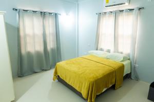 a bedroom with a bed with a yellow blanket at Nook Apartments in Grenville