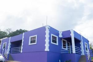 a blue building with stairs in front of it at Nook Apartments in Grenville
