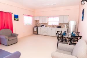 a kitchen with white cabinets and a table and chairs at Nook Apartments in Grenville