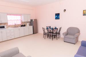 a kitchen and dining room with a table and chairs at Nook Apartments in Grenville +9 photos