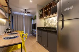 a kitchen with a dining table and a refrigerator at Lindo e moderno próximo ao Expo Center Norte in São Paulo