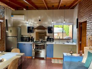 a large kitchen with blue appliances and a table at One Cabañas Vera in Los Antiguos +10 photos