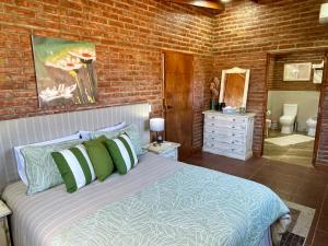 a bedroom with a bed and a brick wall at One Cabañas Vera in Los Antiguos
