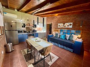 a living room with a blue couch and a kitchen at One Cabañas Vera in Los Antiguos