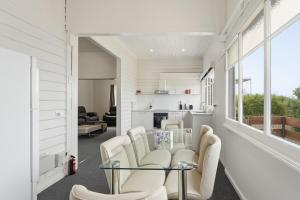 a living room with white chairs and a glass table at Charming Sandy Bay Stay in Sandy Bay