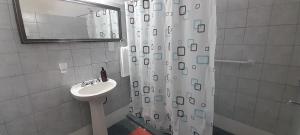 a bathroom with a sink and a shower curtain at Casa Uchita in La Falda +7 photos