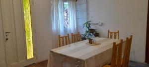 a dining room with a table and chairs and a window at Casa Uchita in La Falda