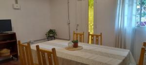 a dining room with a table and chairs and a television at Casa Uchita in La Falda