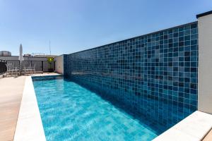 a swimming pool with blue tiles on a building at Lindo e moderno próximo ao Expo Center Norte in São Paulo