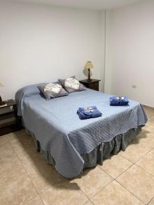 a bedroom with a bed with blue sheets and pillows at Edificio LUMARO in San Fernando del Valle de Catamarca