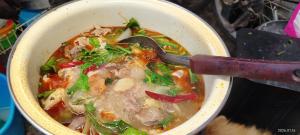 a bowl of soup with a spoon in it at Love in Ban Khlong Chorakhe