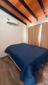 a bedroom with a blue bed in a room at La casita de Ivanna in San Bernardino