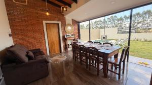 a dining room with a table and chairs and a brick wall at La casita de Ivanna in San Bernardino